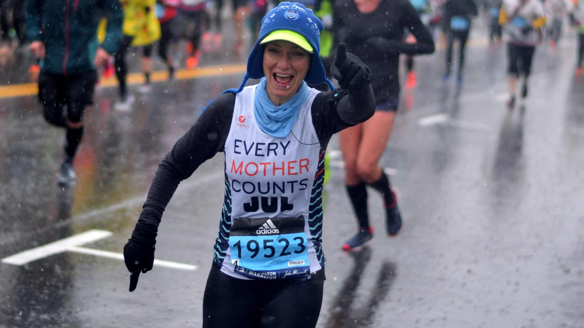Runner at Boston Marathon in the rain, thumbs up